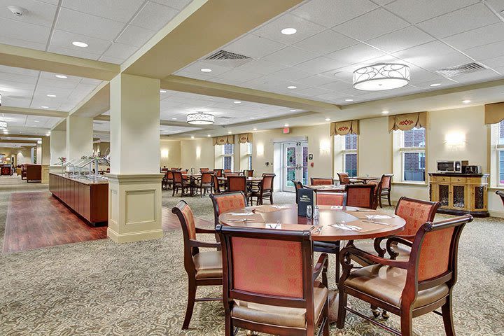 Spacious dining hall with round tables and buffet