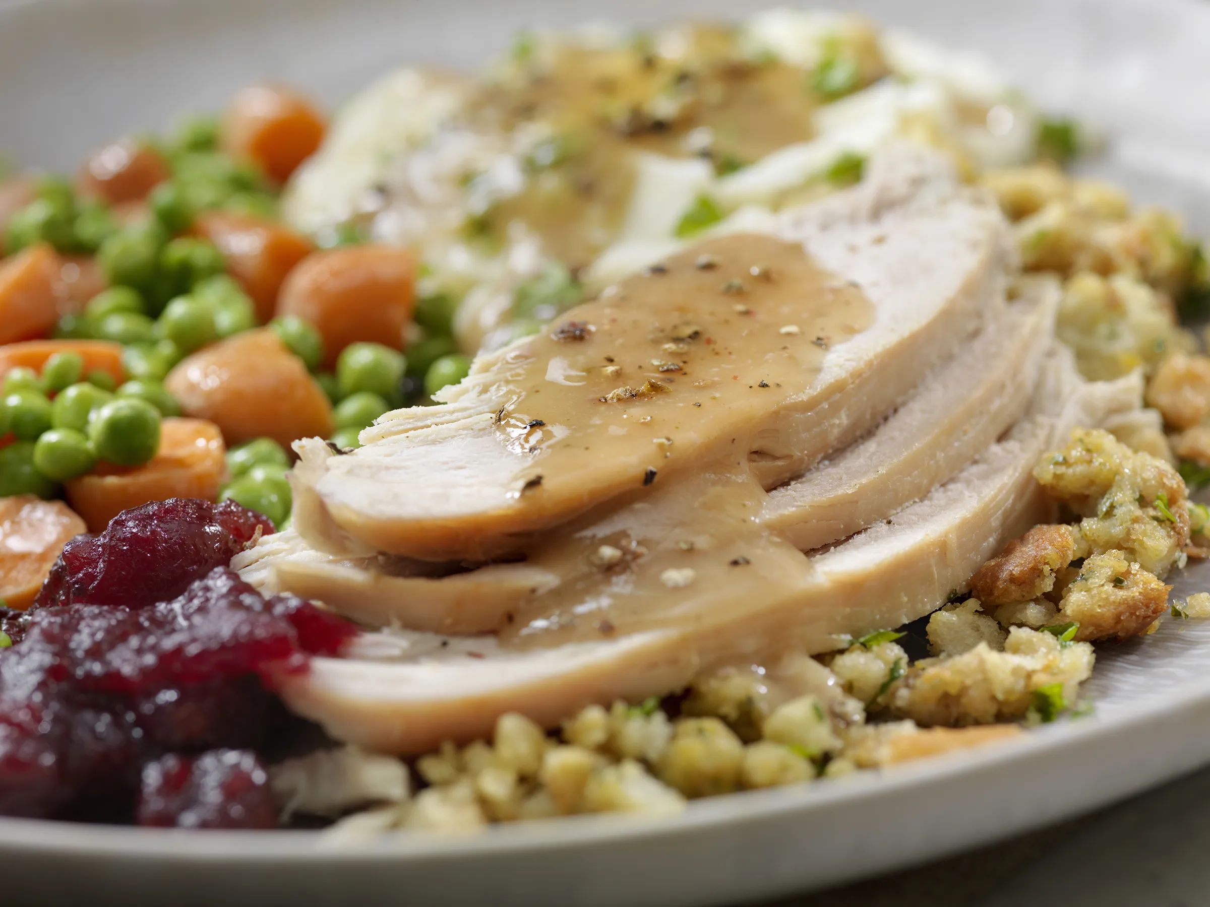 Sliced turkey with gravy and Thanksgiving sides